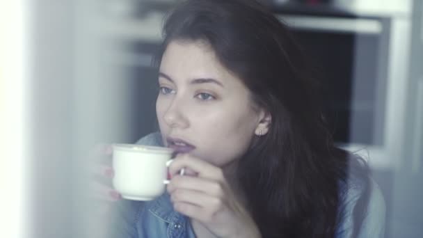 Pensive, thoughtful beautiful woman drinking coffee - Záběry, video