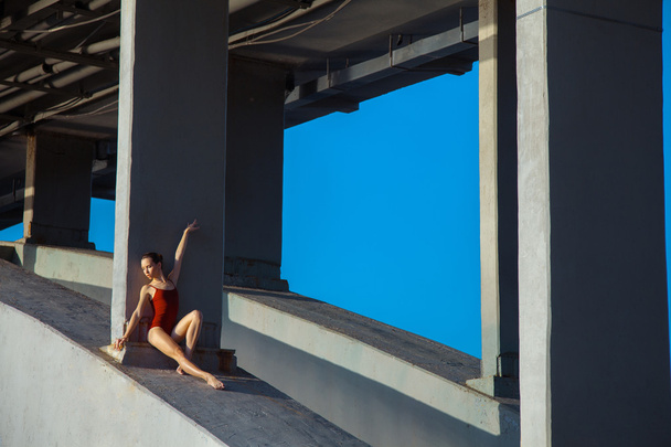 Young beautiful woman gymnast posing on bridge girder - Foto, afbeelding