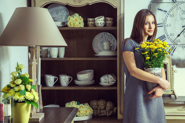 Beautiful young fashion model holding yellow flowers. - Foto, Imagen