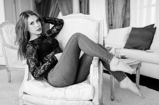 Black and white photography of beautiful young lady relaxing in chair - Фото, зображення