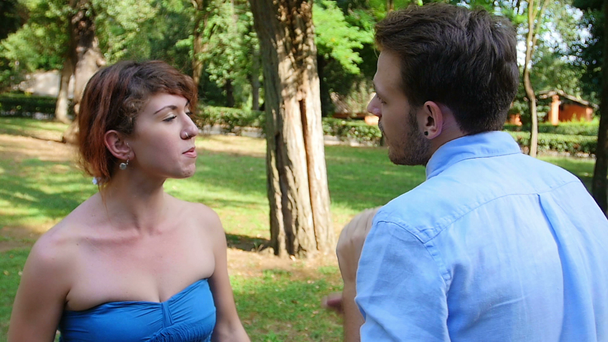 boj proti pár v parku: mladý muž a mladá žena jsou ve sporu - Záběry, video