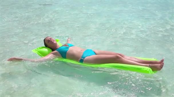 Movimiento lento: sol de la mujer feliz que broncea en colchón inflable del airbed
 - Metraje, vídeo