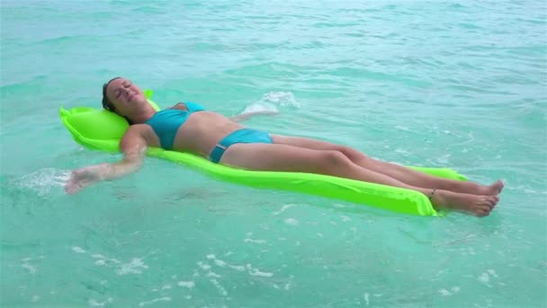 スローモーション:インフレータブルエアベッドマットレスで泳ぐ笑顔の女性 - 映像、動画