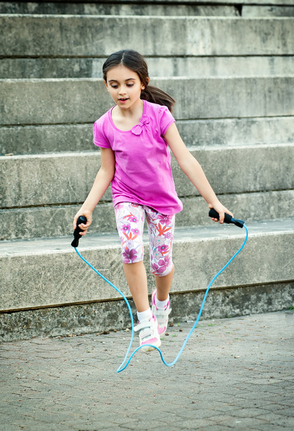 Happy little girl skipping outdoors - Фото, зображення