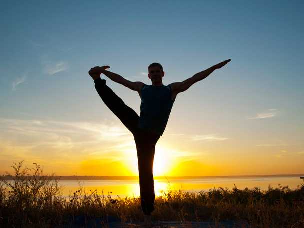 Homem em ioga hasta padangushasana pose de pé ao ar livre
 - Foto, Imagem