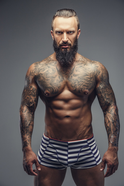 Um homem com tatuagens no corpo
.  - Foto, Imagem