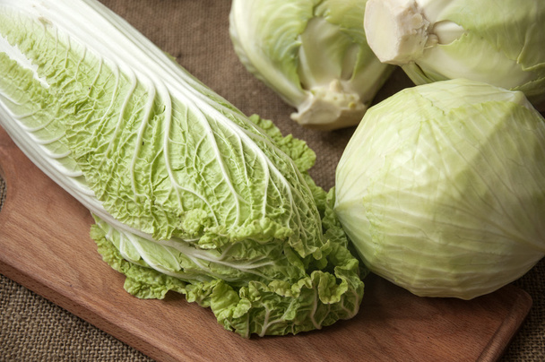 cabbage on a wooden board on a background sacking, burlap - Photo, image