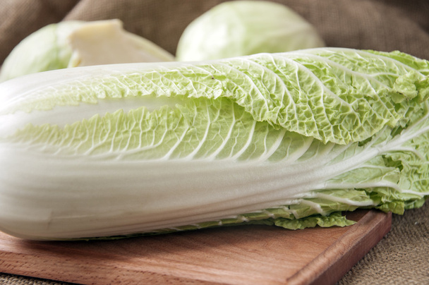 cabbage on a wooden board on a background sacking, burlap - Фото, изображение