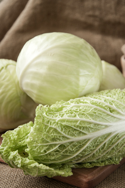 cabbage on a wooden board on a background sacking, burlap  - Foto, Imagen
