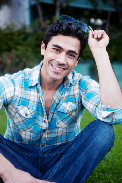 Handsome young man sitting in the grass - Foto, imagen