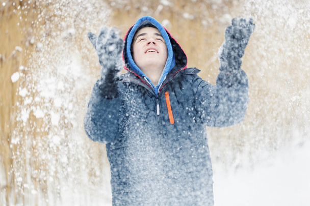 Happy teenager trowing snow - Photo, Image