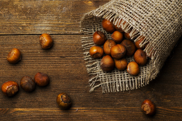 pile of hazelnuts in shell on wooden table  - Valokuva, kuva