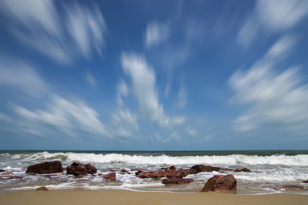 Olas y viento en verano con roca roja en la playa
. - Foto, imagen