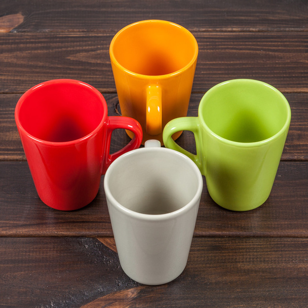 vier farbige leere Teetassen in einem Kreuz angeordnet - Foto, Bild