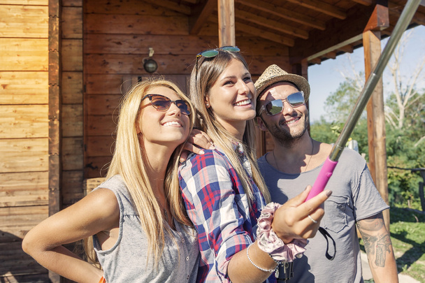 group of smiling friends taking funny selfie with smart phone - Photo, image
