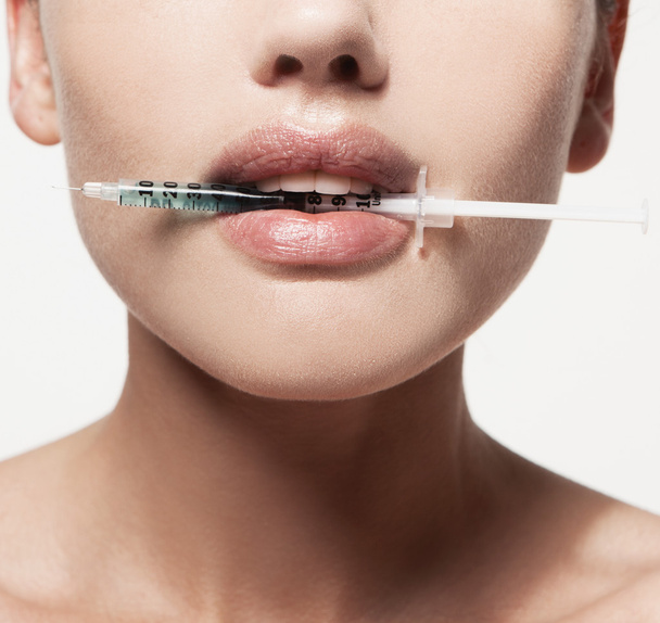 woman with syringe in her mouth - Φωτογραφία, εικόνα
