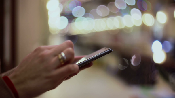 Las manos de la mujer mensajes de texto, utilizando el teléfono inteligente en el centro comercial
. - Metraje, vídeo