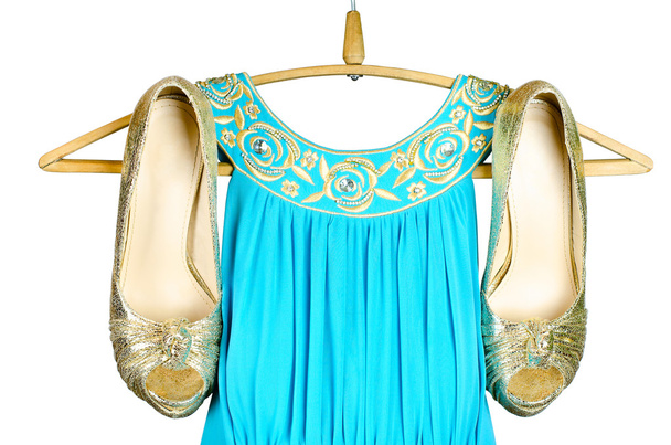 Χρυσά ψηλοτάκουνα παπούτσια και μπλε φόρεμα με χρυσά accentson εμπό - Φωτογραφία, εικόνα