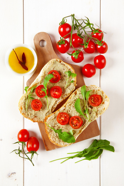 sandwich with cherry tomatoes and cream of avocado and arugula - Zdjęcie, obraz