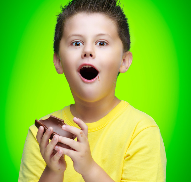 Niño comiendo huevo de chocolate
 - Foto, Imagen