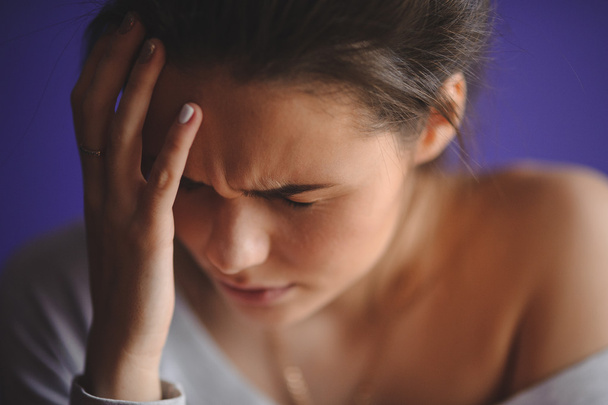Tiener vrouw met hoofdpijn met haar hand op hoofd - Foto, afbeelding