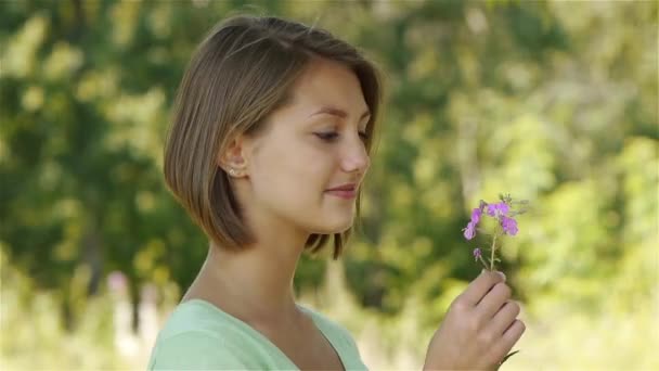 Young beautiful woman smelling flower - Footage, Video
