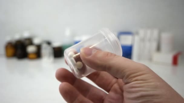 Doctors hand with pills in the measuring cylinder. - Filmagem, Vídeo