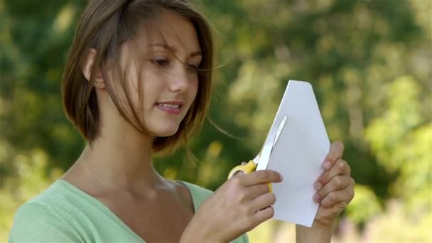Kobieta, cięcie papieru nożyczkami - Materiał filmowy, wideo