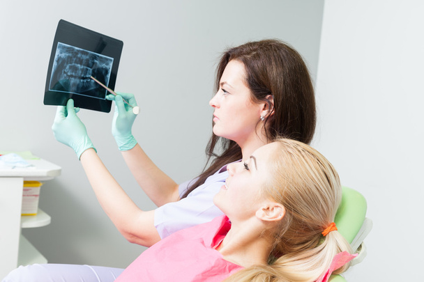 Médico dentista examinando y analizando la radiografía del paciente
 - Foto, Imagen