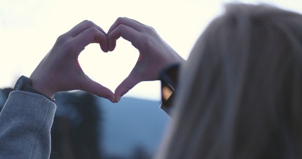 Krásná kavkazské blondýnka ukazuje symbol srdce s prstem - Fotografie, Obrázek