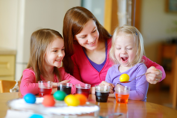 mother and  daughters painting eggs - 写真・画像