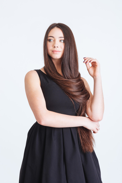 Confident pensive young woman with beautiful long dark hair  - 写真・画像