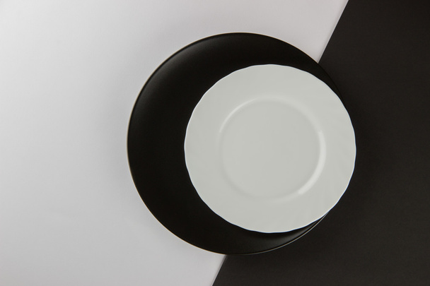 A number of flat plates and cups on black and white background - Photo, image