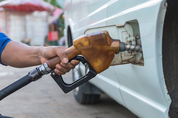 Kezét tartsa üzemanyag fúvókát hozzá üzemanyag töltőállomás autóját - Fotó, kép