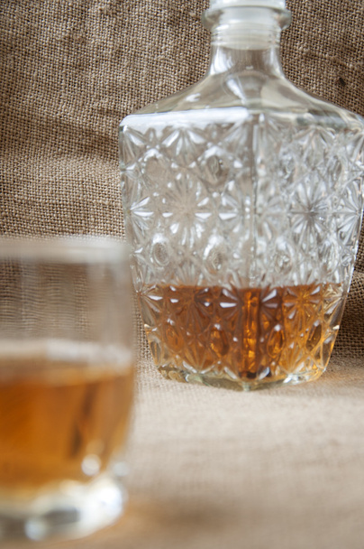 Carafe and glass of whisky, whiskey bourbon on a burlap, sacks  background - Photo, Image