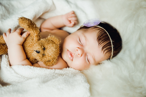 Yeni doğan bebek kız beyaz battaniye sarılmış uyur. - Fotoğraf, Görsel