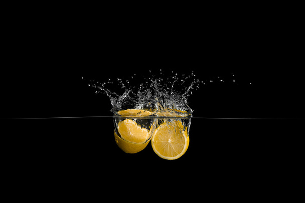 Lemon in water on black background - Zdjęcie, obraz