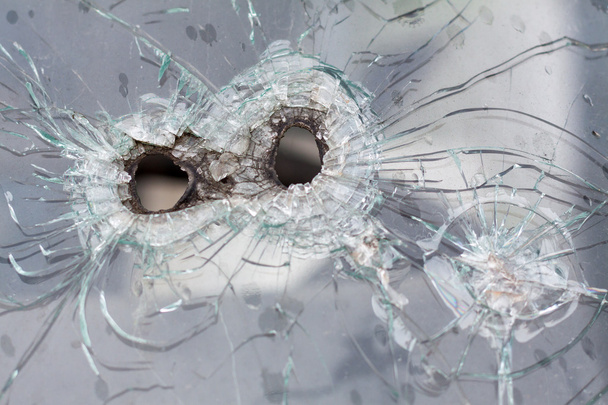 Buracos de balas de espingarda em um vidro de carro
 - Foto, Imagem