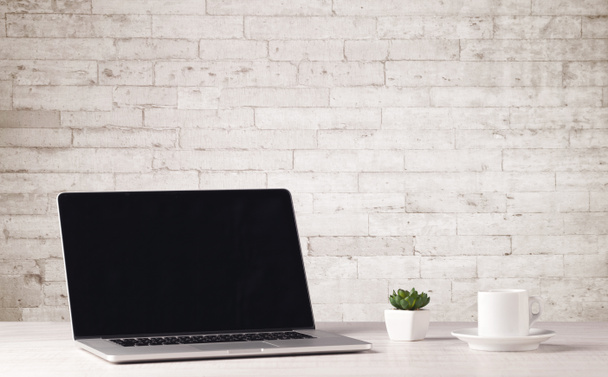 Business laptop with white brick wall - 写真・画像