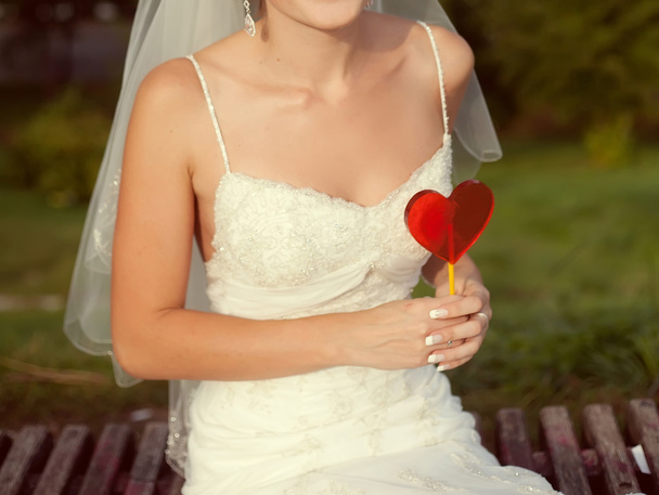 Bride with a red heart in hands - Φωτογραφία, εικόνα