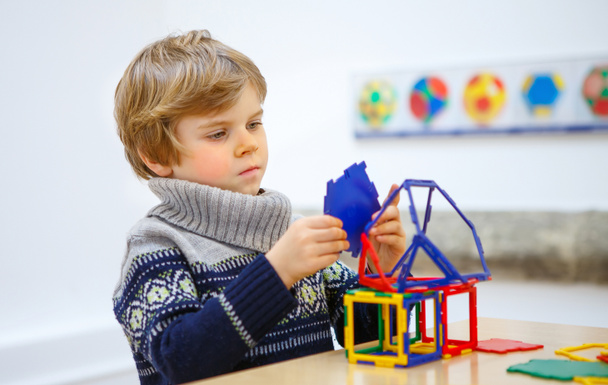 Petit garçon construisant des figures géométriques avec des blocs en plastique
 - Photo, image