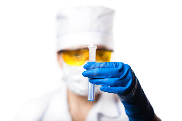 Woman chemist examines test tube  - Foto, afbeelding