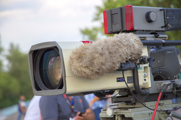 professionelle Videokamera zur Aufnahme von Sportprogrammen. an der Kamera hat ein großes Mikrofon - Foto, Bild