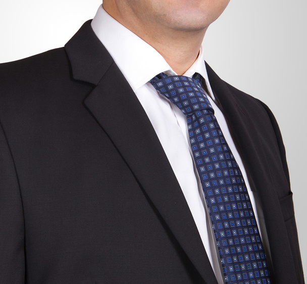 Чорний костюм з білою сорочкою і синьою краваткою
 - Фото, зображення