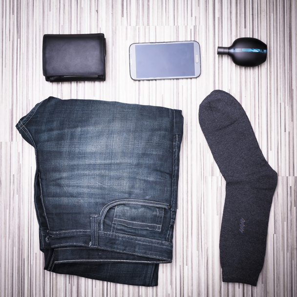 Набір сучасного молодого чоловіка - джинси, гаманець, мобільний телефон, парфуми, шкарпетки. натюрморт
 - Фото, зображення