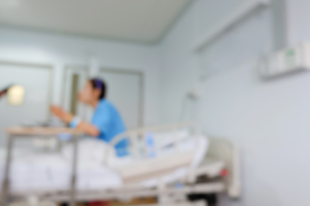 пацієнт сидить на ліжку, розмивання зображення лікарняного фону
 - Фото, зображення