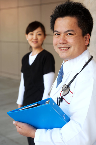 Asian doctor with nurse in background - Photo, Image