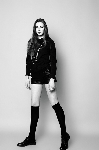 Young girl in black socks and shorts, sitting black and white im - Foto, imagen
