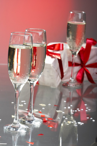 Copas de champán, regalos con cintas rojas y arcos
 - Foto, Imagen