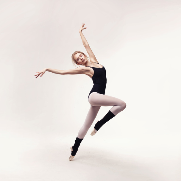 Ballerina in black outfit posing on toes - 写真・画像